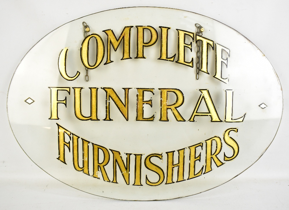 An oval advertising glass sign, 'Complete Funeral Furnishers', 41.5 x 60cm (af).Additional