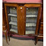 An Edwardian line inlaid mahogany display cabinet with leaded glazed doors enclosing two fixed