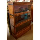 GLOBE-WERNICKE CO LTD; an oak three tier bookcase with up and over doors, height 124cm. Additional