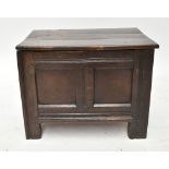 A small early 18th century oak coffer with plank top above panelled front on block supports, width