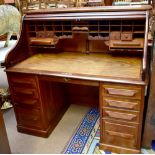 An early 20th century mahogany roll top desk, the shutter door enclosing fitted interior, height