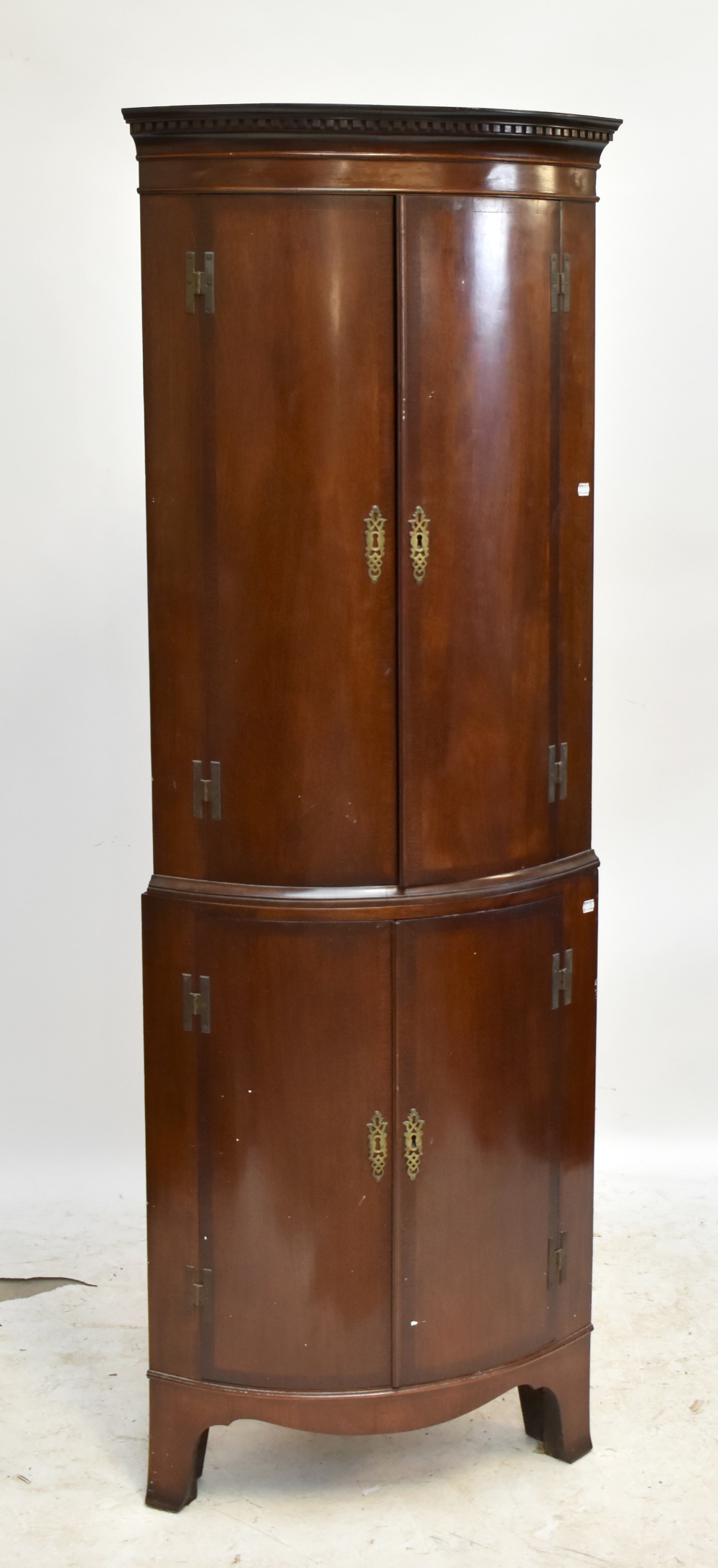 A reproduction crossbanded mahogany freestanding bowfronted corner cupboard, the four doors