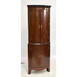 A reproduction crossbanded mahogany freestanding bowfronted corner cupboard, the four doors