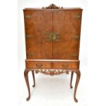 A mid-20th century burr walnut veneered Epstein style cocktail cabinet with twin doors enclosing