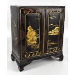 An early 20th century Japanese lacquered cabinet with gilt detail throughout, the twin doors