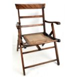 A campaign chair with caned seat.Additional InformationHeavy wear throughout, scratches, scuffs,