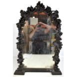 A 19th century carved oak wall mirror with arched top and carved detail of grapes and vine leaves,