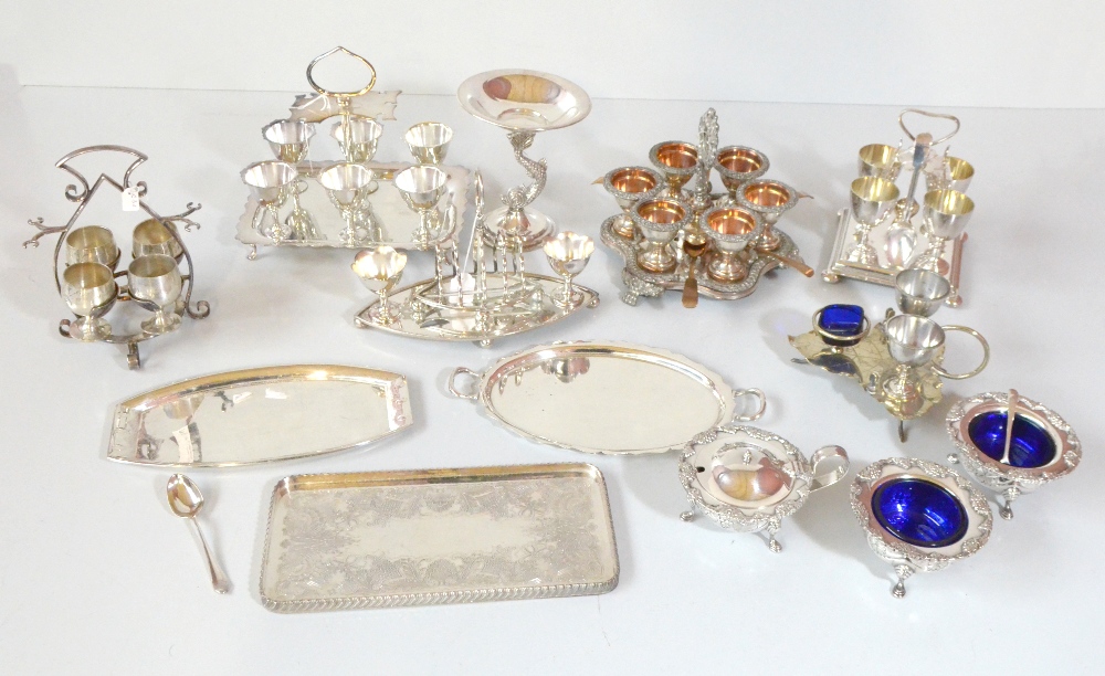 A group of silver plated items including egg stands, a three piece cruet set with cast decoration