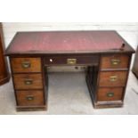An early 20th century mahogany twin pedestal desk with inset writing surface above seven drawers