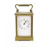 A brass carriage clock with painted dial set with Roman numerals,