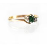 An 18ct yellow gold ring set with central emerald and two diamonds to either side, size P, approx 1.