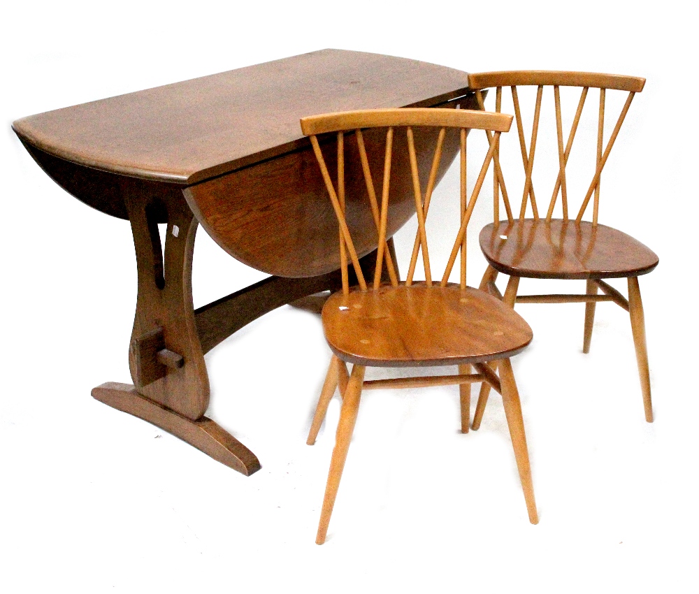 An Ercol c1970s seven-piece elm and beech dining suite comprising drop-leaf dining table with slab