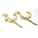 Nine matching gilt metal twin-branch wall sconces in the form of tasselled ribbons,