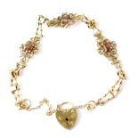 A 19th century 9ct gold bracelet with three red stones within openwork flower heads joined with bow