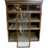 An early 20th century oak bookcase with four sections, each with glazed up-and-over door,