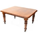 An early 20th century mahogany wind-out dining table with two extra leaves,