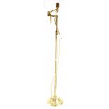 An Edwardian-style floorstanding brass telescopic reading lamp with extending arm.