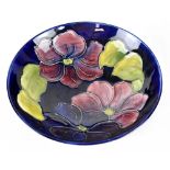 A Moorcroft Pottery bowl raised on a foot, decorated in the 'Anemone' pattern on a blue ground,