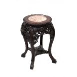 A Chinese hardwood plant stand, rouge marble top to heavily carved sides,