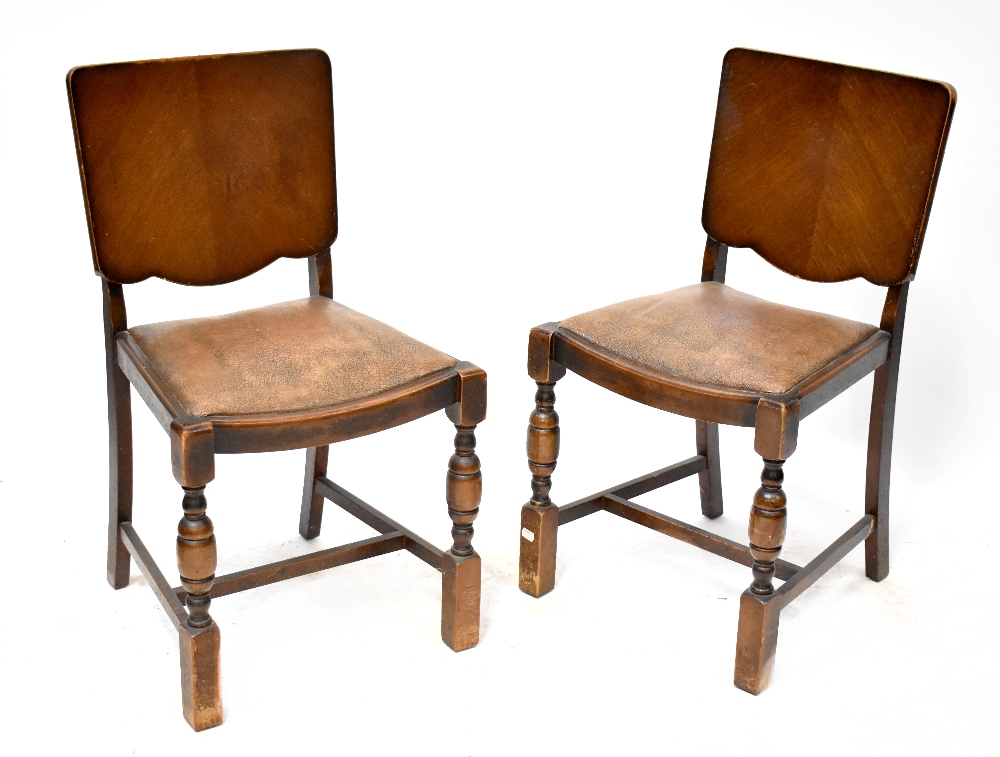 A set of four 1930s oak dining chairs with veneered backs and leatherette upholstered seats (4).