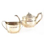 A George III hallmarked silver teapot of oval from, with scroll handle,