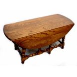 An Ercol drop-leaf coffee table raised on turned and block stretchered supports, height 49cm,