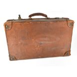 A vintage brown leather suitcase with a Cunard White Star Line label with image of a sailing ship