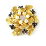 An 18ct gold brooch in the style of a wreath with a ring of seed pearls and groups of three small