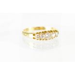 A five-stone diamond ring, five graduated small diamonds in yellow metal shank, unmarked, size P,