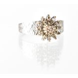 A 1970s 18ct white gold and diamond cluster ring, central raised claw-set diamond approx 0.