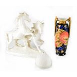 A West German blanc de Chine porcelain figure group of two horses on an oval base,