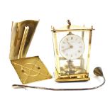A modern mantel clock in the form of a 19th century brass carriage lantern and a plated candle