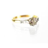 An 18ct yellow gold and platinum diamond solitaire ring with diamond chips to the shoulders,