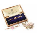 A 15ct gold bar brooch set with diamond in a claw mount and scroll setting, stamped 15ct, maker FST,