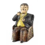 A novelty cast metal moneybank of a seated banker, height 15cm (af).