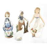 Three Nao figures to include a young girl with flowers in her skirt,