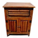 An early 20th century oak side cabinet with small fall-front section above pair of linen fold