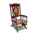 An American stained wood rocking chair with tapestry upholstered back,