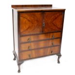 A mahogany tallboy with quart veneered top above pair of doors, above three long drawers,