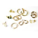 Nine pairs of mostly gold earrings, many of hoop design (9).
