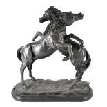 A bronzed figure group of two rearing horses, on naturalistic base and mounted on a stepped plinth,