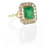 A yellow metal emerald and diamond ring,