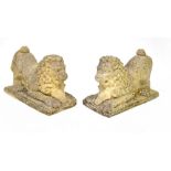 A pair of reconstituted stone garden ornaments in the form of recumbent lions resting on rams'