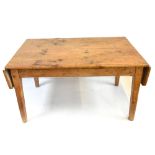 A rustic pine kitchen table with plank top and two short end flaps, length with flaps down 142cm.