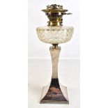 An Art Deco silver plated oil lamp with cut clear glass reservoir and swept base, stamped HE & Co,