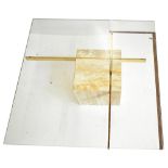 A contemporary glass topped coffee table, raised on two brass plated arms and a marble cube support,