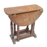 A small early 20th century oak drop leaf table raised on turned and block supports, length 70cm.