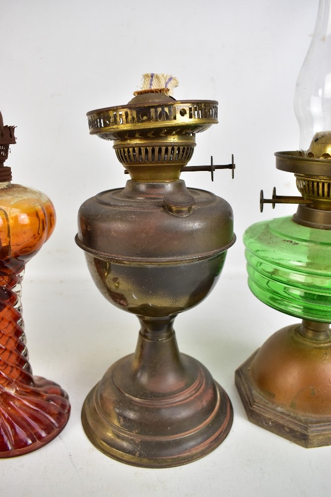 Four vintage oil lamps, one with green glass reservoir, one all brass and one with amber tinted - Image 4 of 5