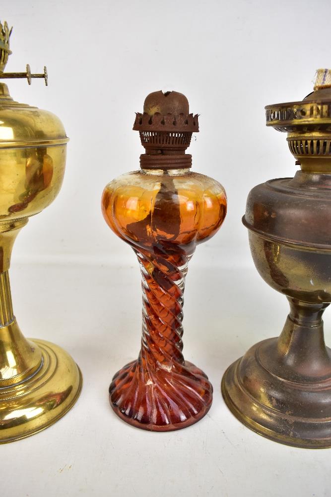 Four vintage oil lamps, one with green glass reservoir, one all brass and one with amber tinted - Image 3 of 5