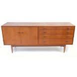 A mid-20th century stained teak sideboard with an arrangement of four drawers flanked on one side by